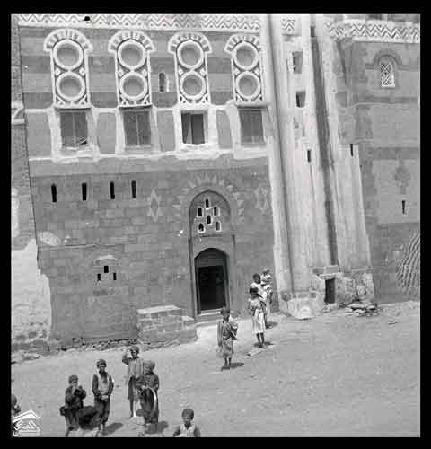 الجزء السفلي من منزل من الطوب مع زخارف بيضاء حول الفتحات الصوره عام1951المصور: كلودي فاين